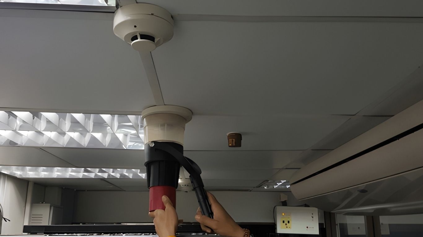 Worker cleaning ceiling area in warehouse Sharjah