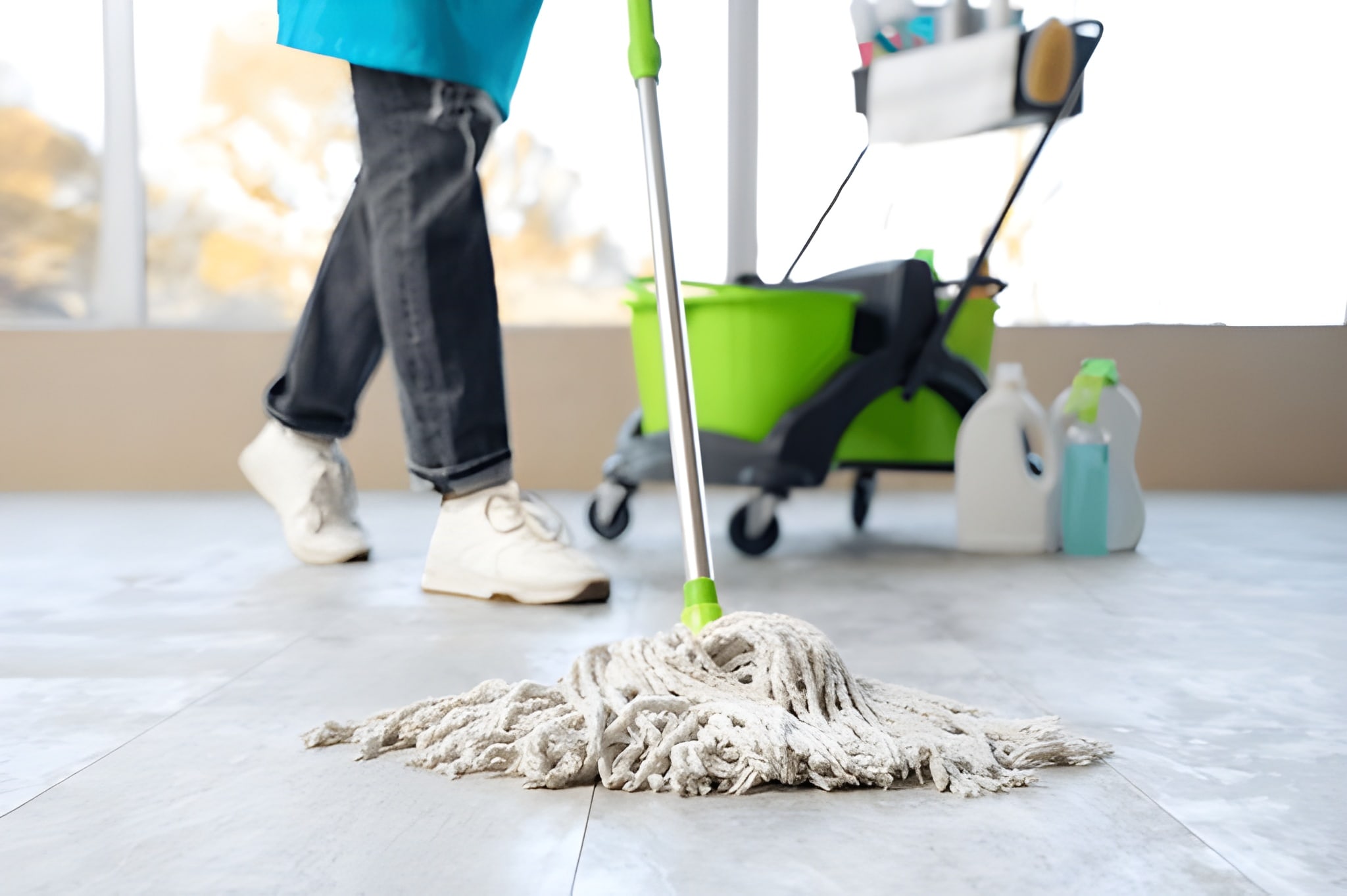 Shop Cleaning Services 8 Cleaner mopping floor with cleaning tools nearby