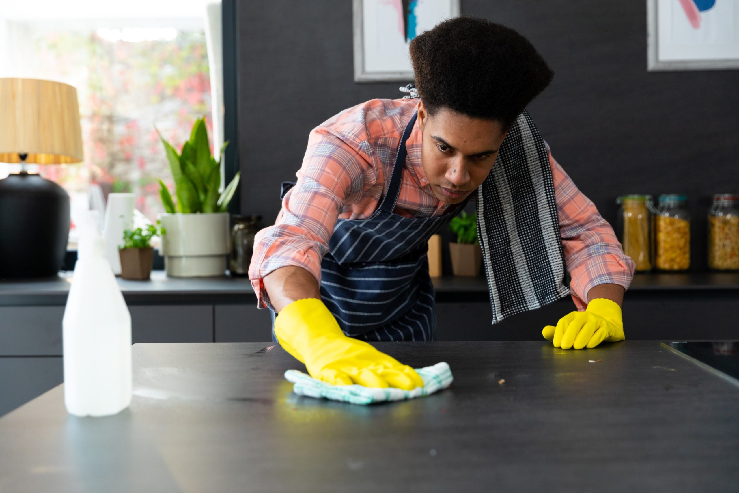 Best Maid Services in Dubai 5 Man wiping kitchen counter during deep and regular cleaning.